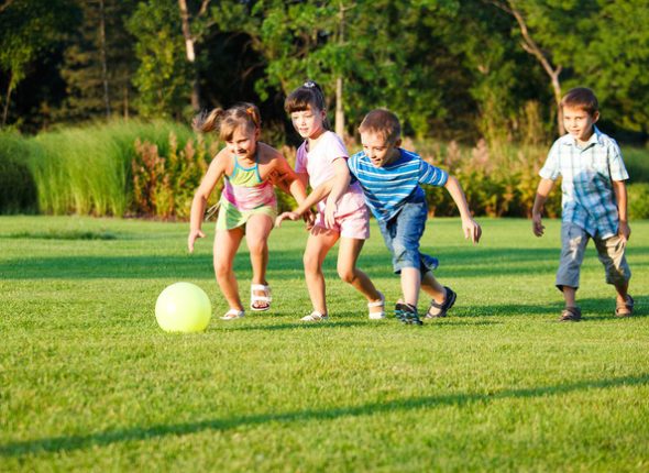 Four preschool kids playing with the ball